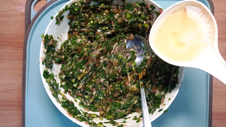 韭菜肉锅贴,淋上热油,继续搅拌