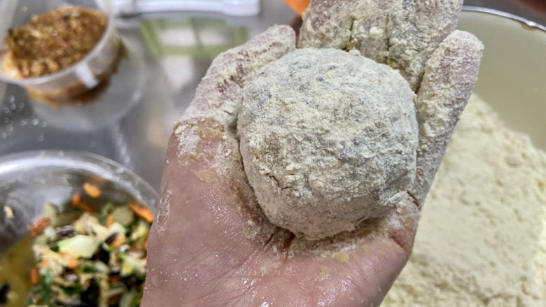 菜团子➕杂蔬玉米面菜团子,放入玉米面中,不断按压,让玉米面包裹粘附在团子表面