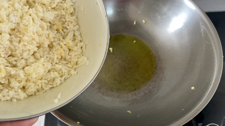 鸡蛋火腿炒饭,炒鸡蛋剩下的油,倒入混合蛋液的米饭,中火不断翻炒,炒到米饭粒粒分明,散发蛋香味