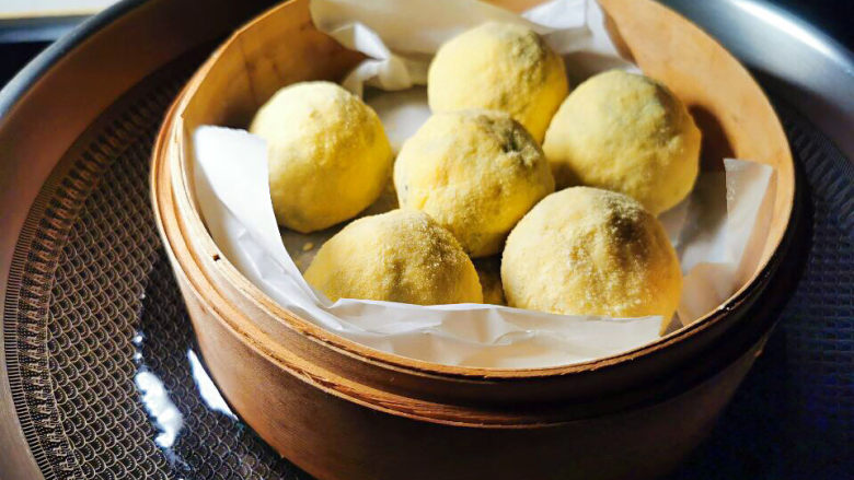 菜团子,做好的菜团子生胚放进垫上烘焙纸的蒸笼,移入蒸锅中