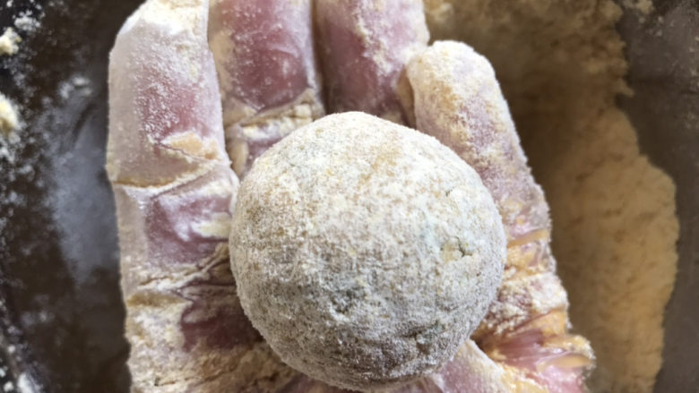 菜团子,再拿在手心轻轻的裹捏,边捏边加玉米面粉,至看不见菜
