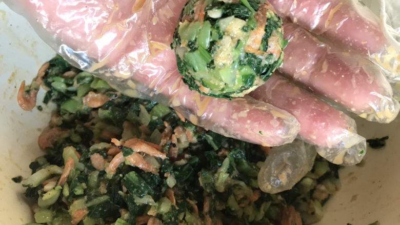 菜团子,用手抓一小把拌好的白菜,捏滚成团