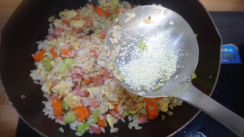 鸡蛋火腿炒饭,放入少许<a style='color:red;display:inline-block;' href='/shicai/ 756'>鸡精</a>,翻炒,一定要小火,否则会焦