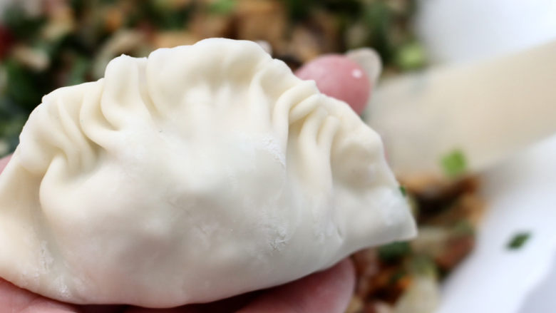 韭菜肉锅贴,两头不包,中间封口后捏几个小花边。