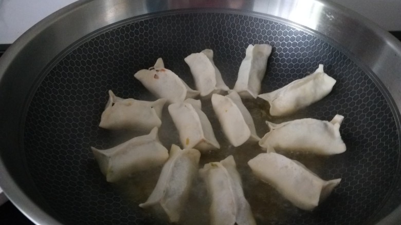 韭菜肉锅贴,小火煎3分钟,底部焦黄后放入100g水