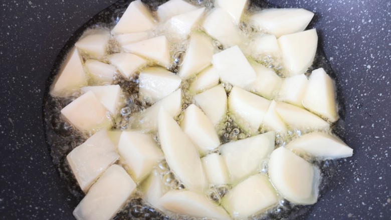 家常地三鲜,炒锅内倒多一些食用油烧至6成热，下入土豆块。