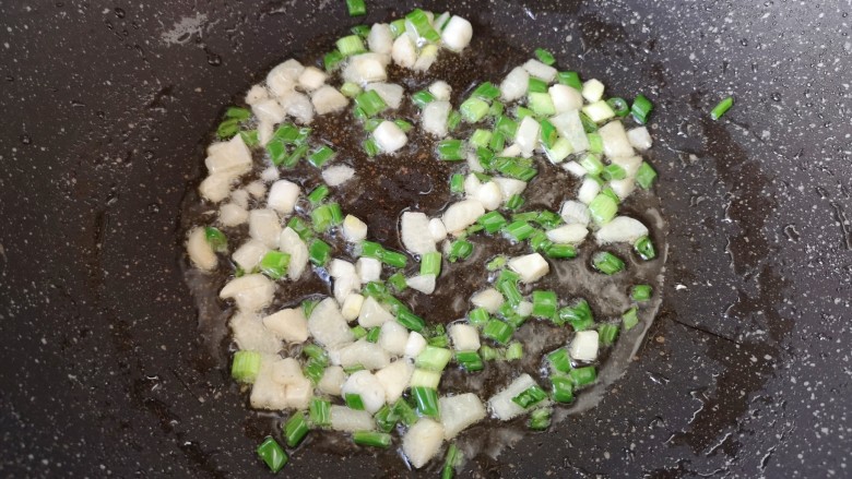 家常地三鲜,锅里的油盛出来一些，下入葱蒜炒香。