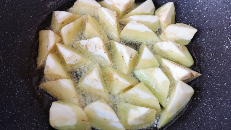 家常地三鲜,茄子下入油锅。