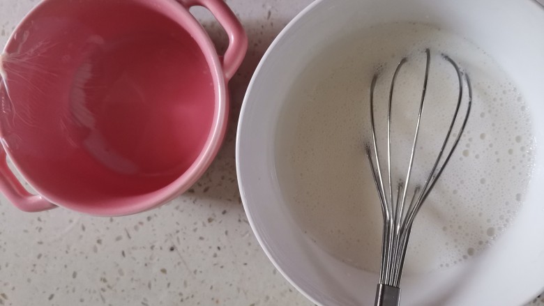 芒果双皮奶,静置好的牛奶表面起了一层奶皮,用筷子从边缘出一个小孔,从边缘把牛奶慢慢倒在蛋清中,底部留一点牛奶,这里我忘记留了