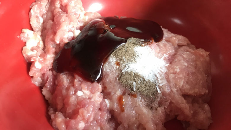 洋葱肉包,加入盐、胡椒粉、味精、酱油和蚝油,充分搅拌均匀