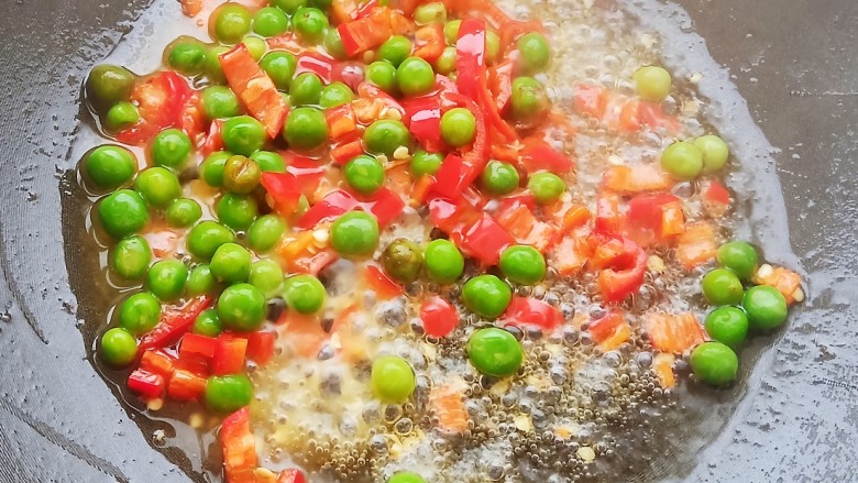 糖醋草鱼,锅中放少许食用油,加入红椒,青豆和火腿丁。