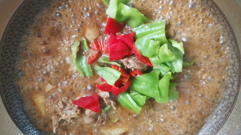 土豆焖鸭,大火收汁,再加入青红椒翻炒至断生即可出锅