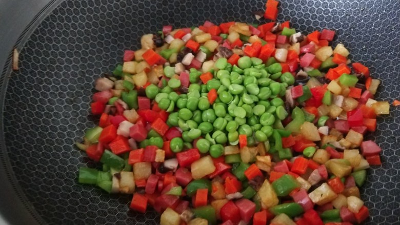 豌豆炒胡萝卜,再加入豌豆,胡萝卜,香菇,青椒丁进行翻炒两分钟