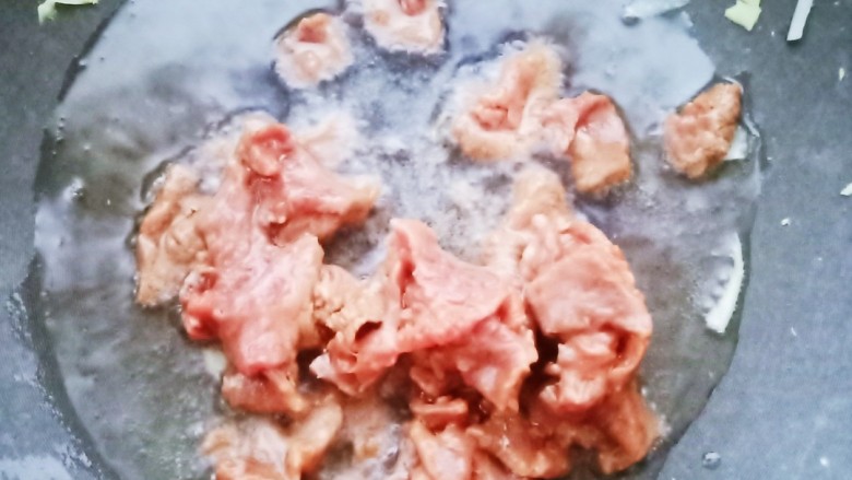春笋炒牛肉,锅中烧油,加入腌好的牛肉炒至变色。