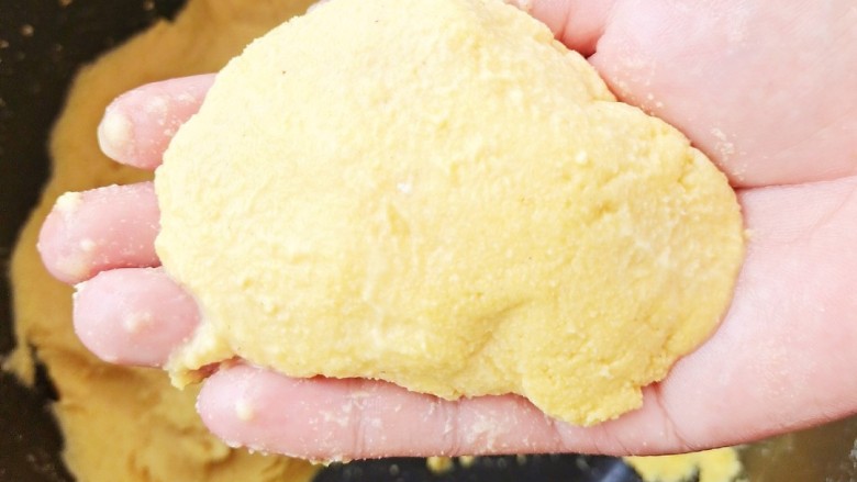 土豆焖鸭,等汤汁收到一半时加入土豆炖煮,并开始准备玉米面锅贴。将醒发好的玉米面揪一小块在手中团成椭圆形。