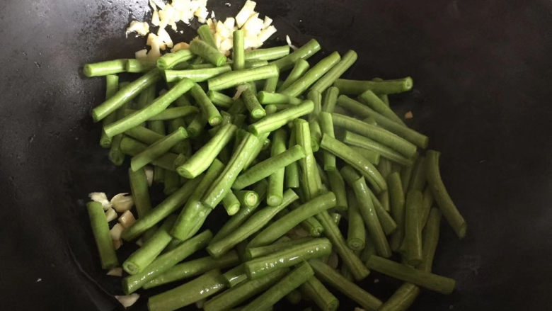 蒜泥拌豆角,倒入豆角翻炒