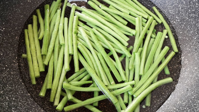 蒜泥拌豆角,锅里放水烧开,加入半勺盐,下入豇豆。