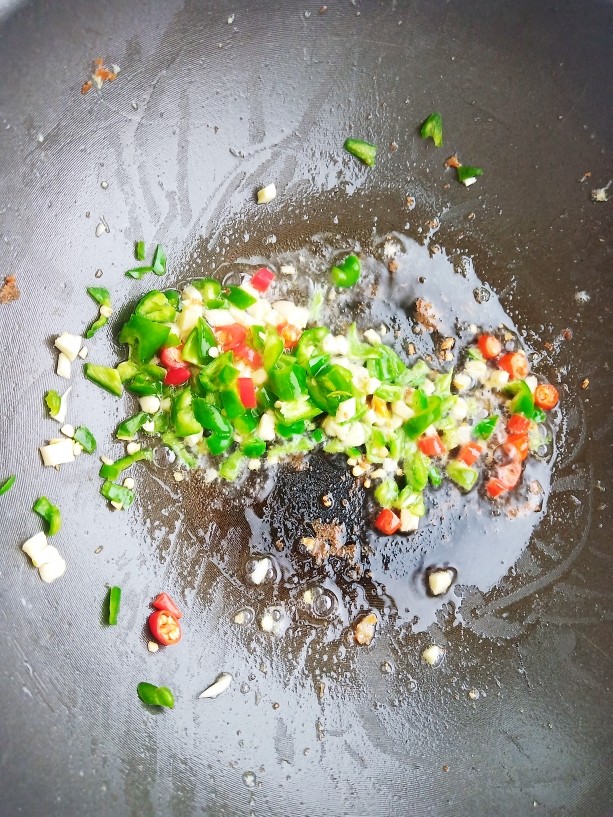 豌豆炒胡萝卜,锅中烧油,爆香蒜末辣椒。