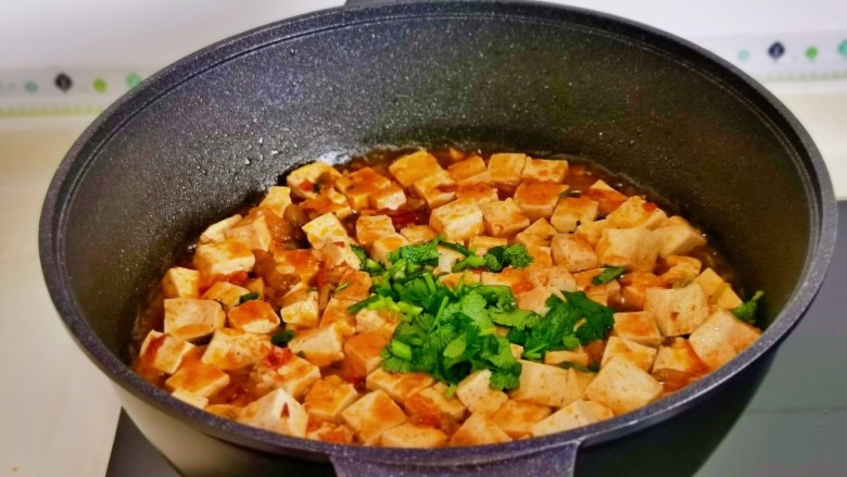 石锅豆腐,大火至浓稠关火,加入切好的<a style='color:red;display:inline-block;' href='/shicai/ 131'>香菜</a>葱花,借助余温烫熟即可。