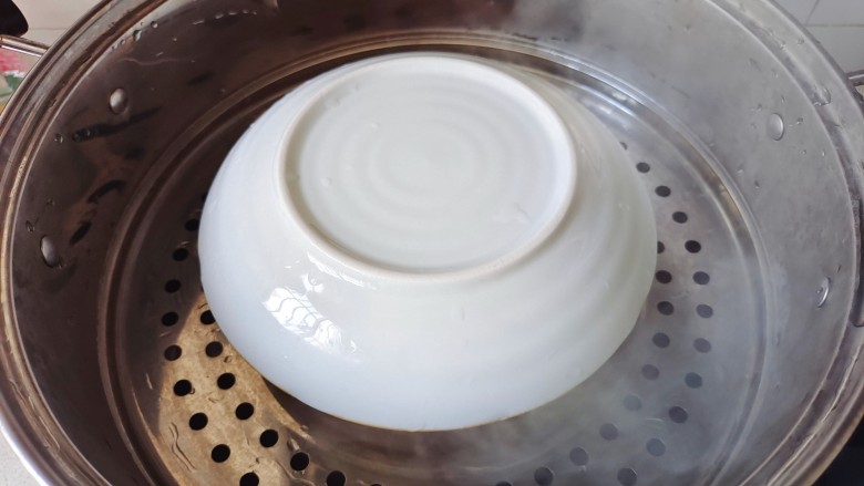 水嫩蒸蛋,鸡蛋液上盖个盘子,防止水蒸气流入鸡蛋液中,锅中加入适量清水煮开,放入鸡蛋液,转中小火蒸10分钟,关火焖5分钟