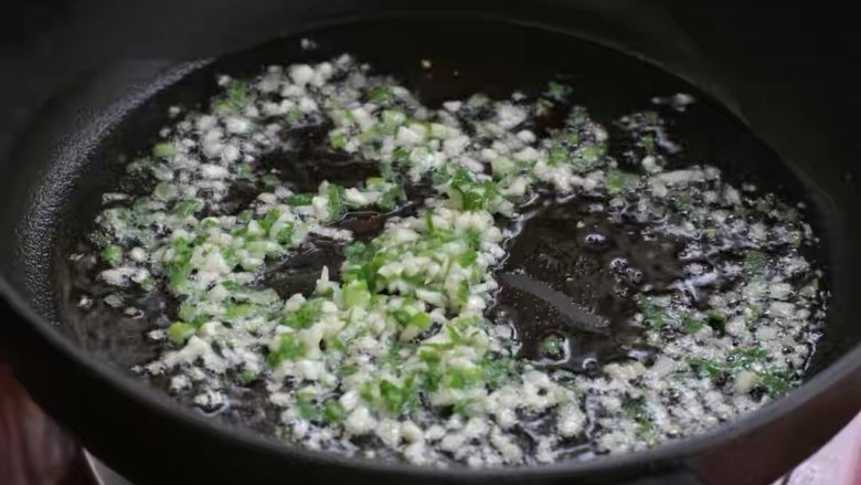 鸡蛋肠粉,锅中倒适量食用油烧至五成热,放入葱花和蒜末小火炒香。