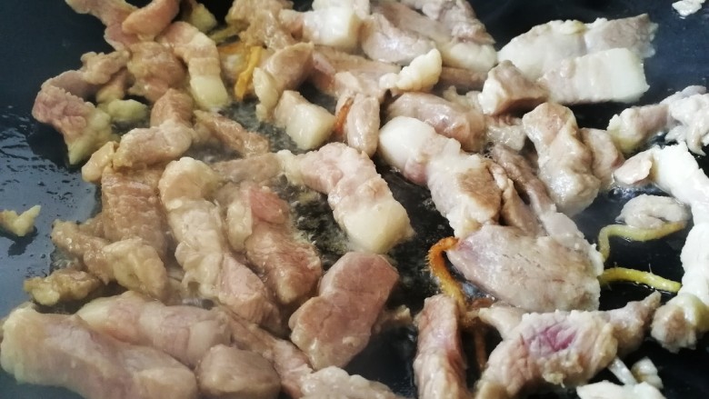 豆角焖肉,放入肉条,文火翻炒,把肥肉的油脂炒出来。