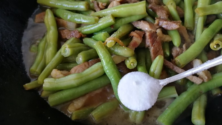 豆角焖肉,大火烧开,加盐调味。