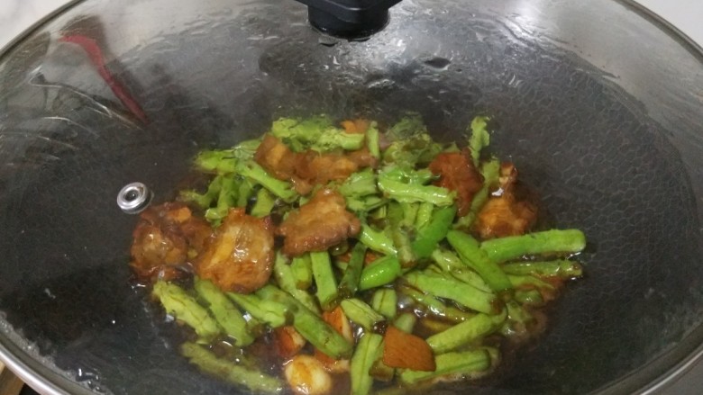 豆角焖肉,盖上盖子中火焖煮一会,让豆角充分吸收汤汁更入味儿