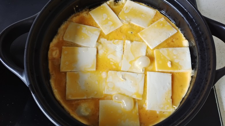 石锅豆腐,淋入鸡蛋液,待鸡蛋液几乎凝固