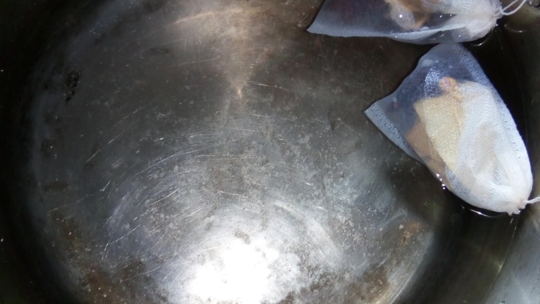 香卤鸭脑壳,锅中加水,放入香料包,大火煮。