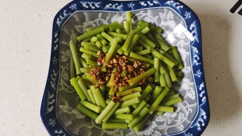 凉拌蒜苗,将调好的料汁浇在蒜苔上,用筷子翻拌均匀即可
