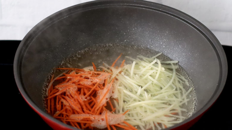 低卡饱腹的生菜卷,锅中倒入适量清水加少许盐烧开,放入土豆和胡萝卜丝烫熟。