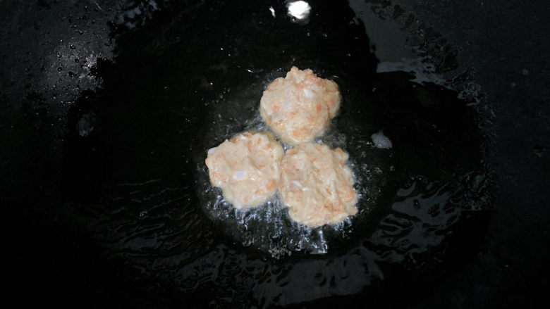 胡萝卜鸡肉饼,锅烧热油,将胡萝卜、肉泥,舀成小饼。