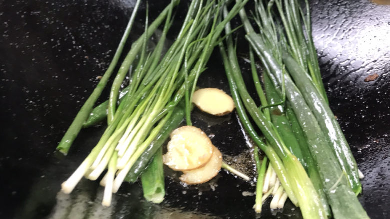 葱烤鲫鱼,就着锅里的油,放入姜片和香葱,煎香