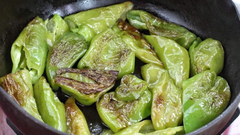 煎酿辣椒,待辣椒变软、表皮呈现焦黄的褶皱状翻面,继续小火煎制,直到两面都呈现虎皮状态盛出。