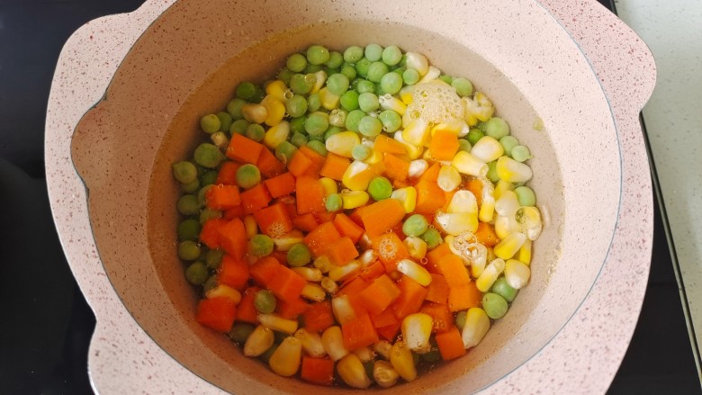 彩蔬火腿丁,锅中加入适量清水煮开,放入少许盐和食用油搅拌均匀,放入胡萝卜丁、玉米粒、<a style='color:red;display:inline-block;' href='/shicai/ 148'>豌豆</a>粒焯水2分钟捞出沥干水分备用。