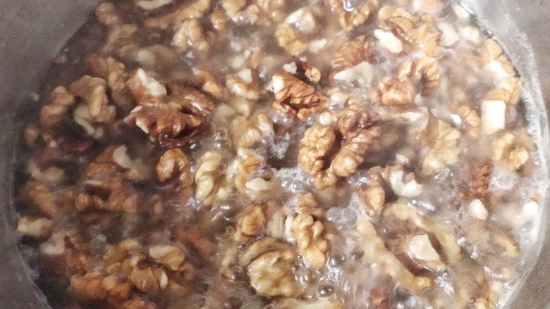 琥珀核桃仁,锅里水开,煮两分钟,水变混浊,核桃颜色变淡,这样可以减少核桃皮的苦味