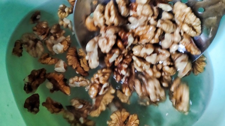 琥珀核桃仁,把煮好的核桃捞出再放入水中清洗一下,晾干