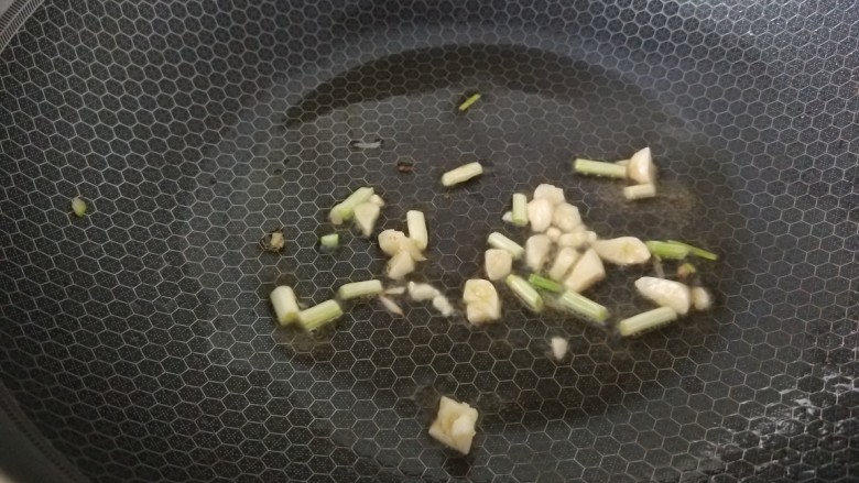彩蔬火腿丁,起锅烧油,油热下入蒜末