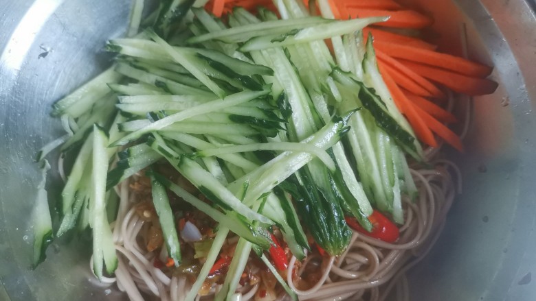黄瓜拌面,黄瓜丝,胡萝卜丝和调好的蒜汁倒入面条里面