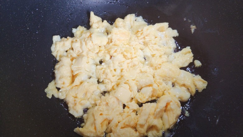 虾仁韭菜炒鸡蛋,起油锅,油热后下鸡蛋液,翻炒至鸡蛋液凝固结块