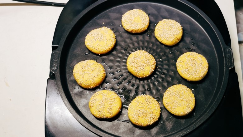 芝麻红薯饼,煎烤机刷油提前预热，将芝麻红薯饼胚码放到煎烤机。