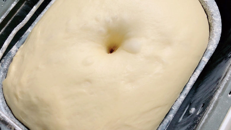 奶香小面包,面团变成2.5倍大,用手指沾面粉轻轻捅入面团,拔出手指后孔洞不塌陷也不回缩,就表示发酵好了。