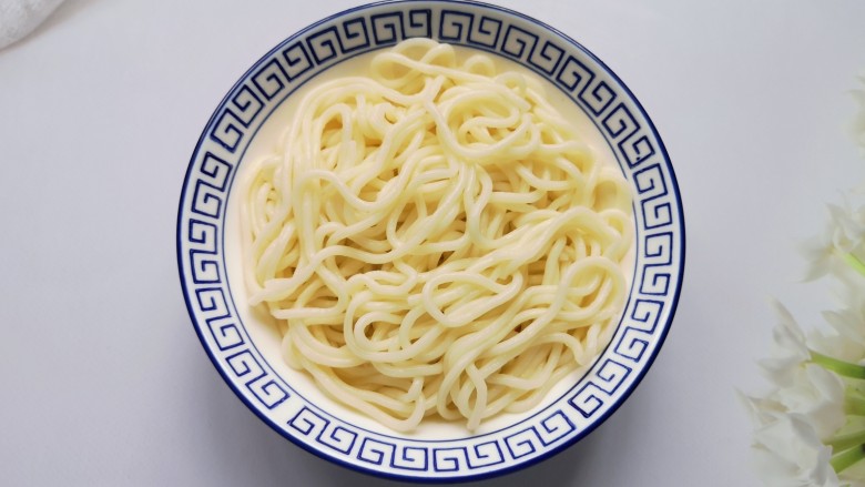 小白菜肉丝面,面条煮熟后过凉水,控一下水分盛入碗里。