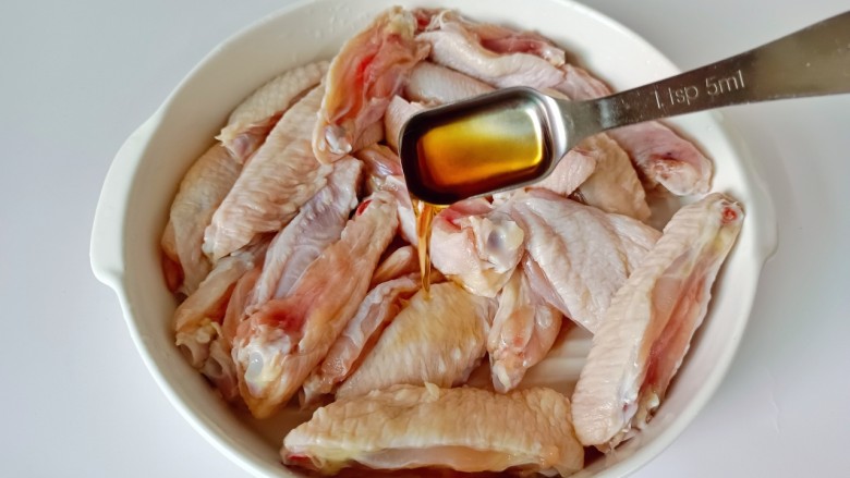 柠香鸡翅,鸡翅对半剪开,加入料酒去腥。