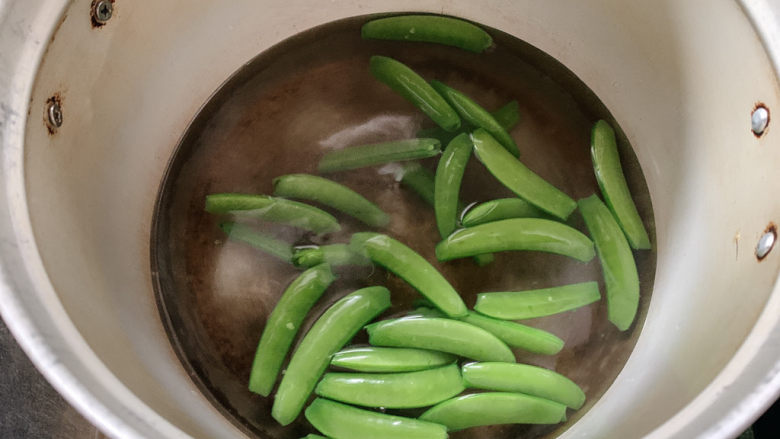 荷兰豆炒鸡蛋,荷兰豆折去两头,加到沸腾的水中汆烫一下,同时可加少许盐或油,保持荷兰豆翠绿状态。