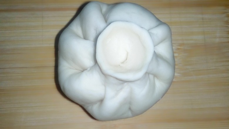 茴香白菜肉包,右手大拇指和食指捏包子褶,左手转动,包包子。