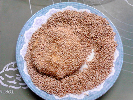 芝麻红薯饼,放入芝麻堆里,两面沾满芝麻。
