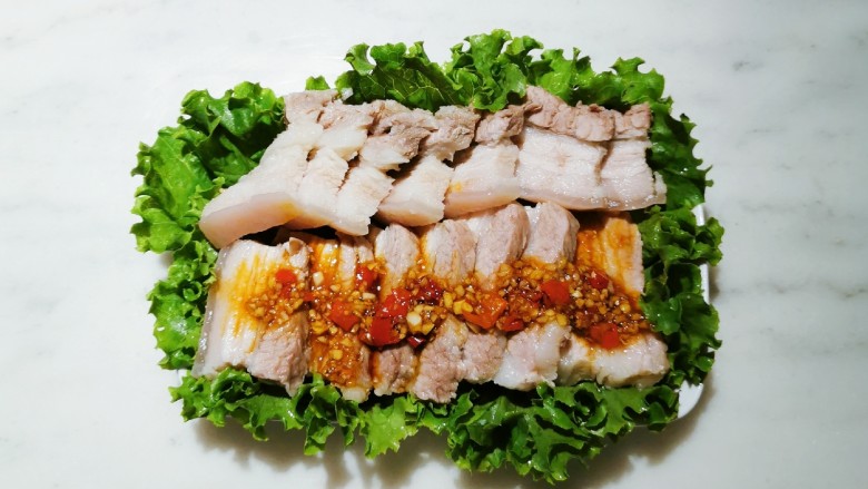 生菜卷五花肉,食用时,撕一块生菜包裹上一片五花肉,卷起来大口吃下,清香不腻。