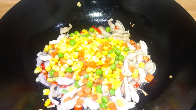 肉末辣炒玉米粒,辣味出来后,倒入玉米粒,胡萝卜丁,豌豆翻炒